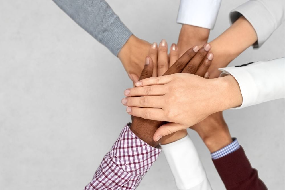 Hands that representing the blending of two firms.